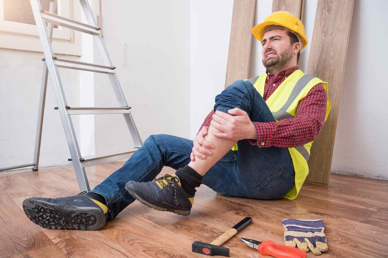 Trabajador lesionado en el piso de una obra junto a sus herramientas